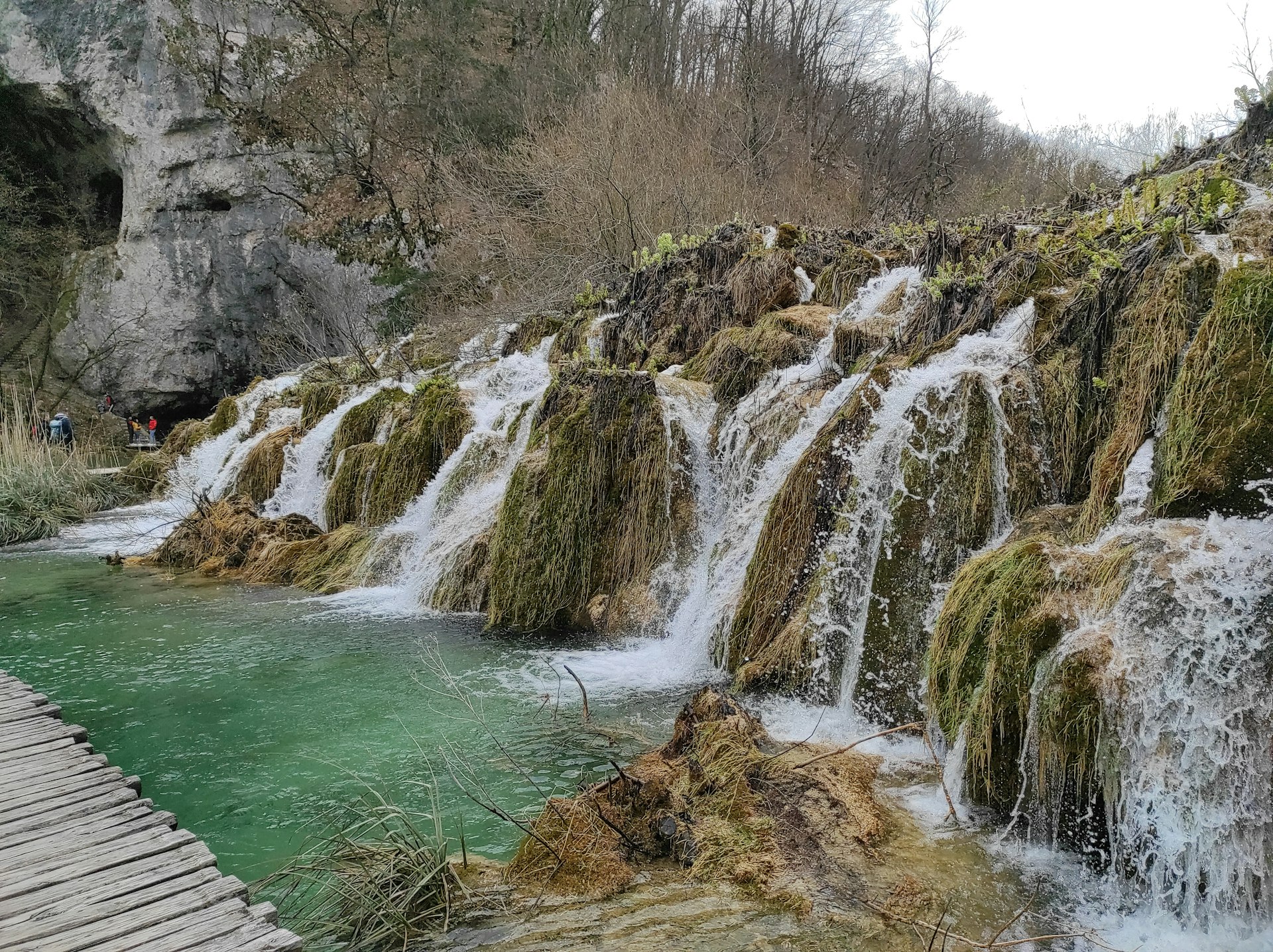 Water falls over mossy rocks at Plitvice Lakes during spring season